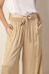 Pantalón palazzo negro de rayón y viscosa, con cintura elastizada, lazo y bolsillos laterales.