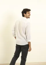 Camisa azul marino de lino y algodón, con cuello abotonado, manga larga con puños enrollados, bolsillo de parche en el pecho y cierre frontal con botones.