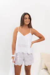 Pijama de algodón blanco con bordado calado, compuesto por musculosa con escote en V y short con cintura elástica y volados.