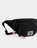 Riñonera negra de tela deportiva con correa regulable, cierre superior con tirador de cordón y goma, bolsillo frontal con cierre y etiqueta de goma con texto "Brooklyn New York - NY Est. 1970".