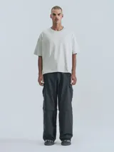 Pantalón negro tipo cargo con bolsillos laterales y corte holgado.