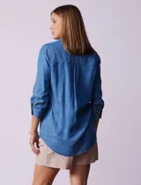 Blusa celeste de lyocell, con cuello con solapa, escote en V y abertura con botones. Mangas ¾ con puño y botón.