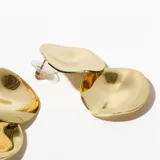 Aros tipo botón dorados con superficie irregular.