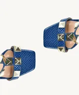 Sandalias de tacón alto color azul con textura de piel de serpiente y apliques de tachas piramidales doradas.