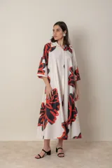 Vestido italiano de algodón con estampado abstracto en tonos blanco, rojo y negro. Modelo suelto abotonado al frente, con cuello camisero y mangas tres cuartos.