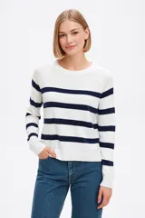 Sweater blanco con rayas horizontales azul marino, de tejido de punto suave y corte clásico.