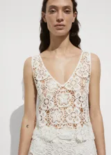 Top de crochet color blanco con escote en V y sin mangas.