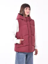Chaleco puffer color borgoña con capucha y cierre frontal con botones a presión.