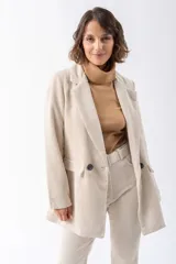 Blazer color beige de pana con solapas de muesca, cierre frontal con un botón, bolsillo de parche y corte holgado.