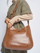 Bandolera marrón de cuero sintético con correa ajustable y logo triangular metálico.