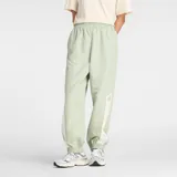 Pantalón deportivo New Balance, color verde menta, de corte holgado con cintura elástica y puños ajustados. Presenta paneles laterales en color crema con el logo de New Balance bordado en la parte inferior de la pierna.