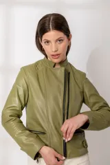 Chaqueta de cuero color verde oliva, estilo motoquera, con cierre frontal cruzado grueso en negro, cuello solapa y detalles acolchados en hombros y codos.