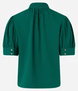 Blusa verde esmeralda de crepé con cuello alto, botones dobles y pequeña abertura en el cuello. Tiene mangas cortas abullonadas con botones.
