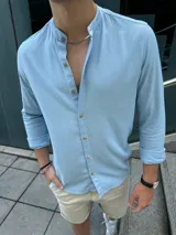 Camisa celeste de lino con cuello mao, manga larga y abotonadura frontal.