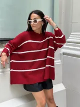 Sweater de punto color bordó con rayas horizontales blancas, de corte holgado y mangas largas.