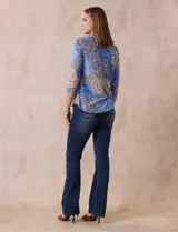 Blusa de modal estampada con motivos paisley en tonos azules, naranjas y amarillos. Tiene escote redondo y mangas tres cuartos.