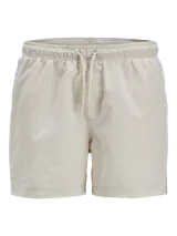 Short de baño color beige con finas rayas verticales en relieve, cintura elástica con cordón ajustable, bolsillos laterales y trasero. Confeccionado en tejido seersucker de poliéster.