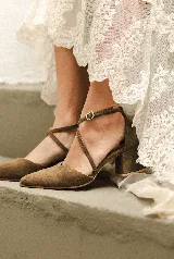 Zapato de tacón bajo color negro, con punta fina y tiras cruzadas sobre el empeine.