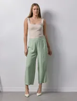 Pantalón de lino color crudo, de corte ancho y largo cropped, con bolsillos laterales.