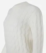 Suéter de punto pesado color crema, con textura trenzada y cuello redondo.
