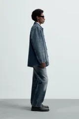 Sobrecamisa relaxed fit confeccionada en denim de algodón con efecto lavado. Tiene cuello solapa, manga larga, bolsillos frontales de plastrón y cierre frontal de botonadura.