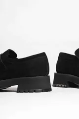 Mocasín de gamuza color verde oliva, con tira superior y suela track gruesa y negra.