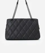 Bolso de hombro mediano color blanco con diseño acolchado en forma de rombos. Tiene asa de cadena plateada, cierre de cremallera y bolsillo frontal con botón a presión.