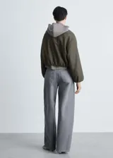 Chaqueta bomber verde oliva de lana con cierre frontal con cremallera, cuello redondo, puños y bajo elásticos.