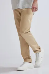 Pantalón chino color beige de corte recto con bolsillos laterales y traseros. Tobillos con dobladillo.