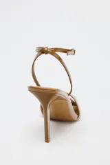 Sandalias color caramelo de charol con tira delantera, pulsera tobillera con hebilla y tacón fino alto.