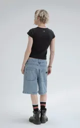 Bermuda de denim azul claro con efecto desgaste, corte oversize y estilo carpintero con bolsillo lateral.