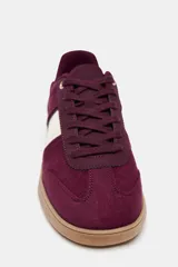 Zapatillas deportivas color borgoña con detalles en blanco y suela color caramelo.