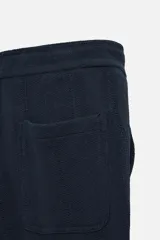 Pantalón azul marino de corte relaxed fit, confeccionado en tejido con mezcla de algodón. Presenta cintura elástica ajustable con cordón, bolsillos frontales y detalle de bolsillo trasero de plastrón.
