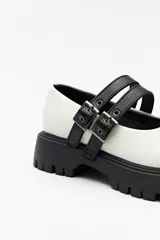 Guillerminas blancas de cuero sintético con suela track negra y doble tira ajustable con hebillas metálicas.