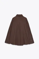 Camisa marrón de algodón, corte amplio, con cuello solapa, manga larga con puños, bolsillo de parche en el pecho, pinzas en la espalda y cierre frontal con botones.