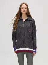 Sweater tejido de algodón color rosa claro, con cuello polo con cierre de cremallera metálica y mangas largas con puños a rayas de colores.