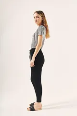 Pantalón babucha negro con cintura elastizada y cordón ajustable.