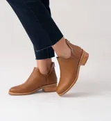 Botines negros de cuero vacuno con textura tejida, taco de madera de 4cm y cierre trasero.