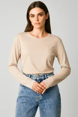 Remera de manga larga confeccionada en algodón de color blanco, con cuello redondo y un bolsillo aplicado en el pecho. Presenta un diseño de calce al cuerpo.