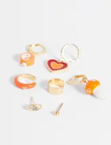 Set de caravanas con diseños variados, incluyendo dijes de corazón y hongo en tonos naranja y rojo.