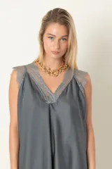 Blusa de satén de seda color beige con escote en V y hombros de encaje, de calce holgado y diseño elegante.