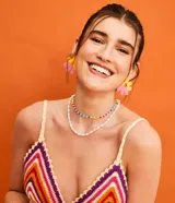 Top cropped tejido al crochet con diseño de rayas horizontales en tonos naranja, rosa, violeta y amarillo.