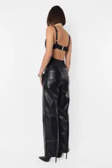 Pantalón recto de cuerina color negro, de tiro medio-bajo, con bolsillos delanteros y traseros, presillas en la cintura y cierre metálico.