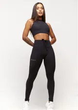 Calza deportiva negra de tiro alto con cordón ajustable en la cintura y logo estampado en la pierna.