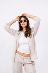 Camisa a rayas verticales color beige y blanco, con cuello clásico, cierre frontal con botones y mangas largas.