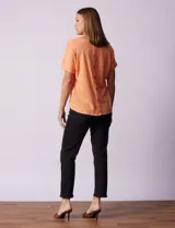 Remera color durazno con textura y espalda con aplique de botones.