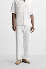Pantalón azul marino de corte amplio, confeccionado en tejido de mezcla de algodón y lino. Cuenta con cintura elástica ajustable con cordón, bolsillos frontales y bolsillos traseros de vivo.