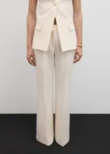 Pantalón de vestir color crema, de corte acampanado y tiro alto.