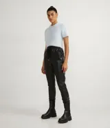 Pantalón jogger negro de material sintético con cintura elástica ajustable con cordón, bolsillos laterales y puños elásticos.