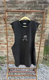 Musculosa sin mangas color negro con efecto gastado (acid wash) y un pequeño estampado frontal de una figura humanoide con sombrero de hongo.